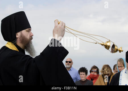 Lemnos Island, Grecia. 3 Ottobre, 2015. Sacerdote russo officiates presso il memoriale di servizio spostando un incensory in aria presso il cimitero di Russian-Kozak sulla punta del capo, Lemnos, Grecia. Credito: BasilT/Alamy Live News Foto Stock