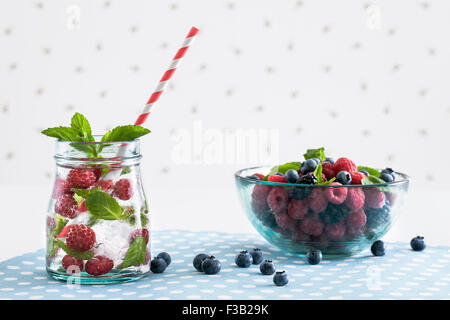 Lamponi freschi mojito con frutti di bosco su un bianco polka-sfondo puntinato Foto Stock