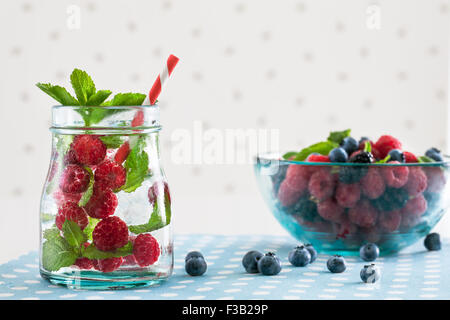 Lamponi freschi mojito con frutti di bosco su un bianco polka-sfondo puntinato Foto Stock