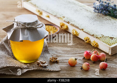 Ancora in vita con un barattolo di vetro pieno di miele, mele nana, un mazzetto di lavanda, favi telaio e un raccordo a t la coppa con polline di api. Foto Stock