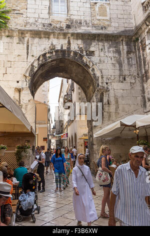 Turisti e popolazione locale in corrispondenza di una piccola strada pedonale presso il Palazzo di Diocleziano a Split, Croazia. Foto Stock