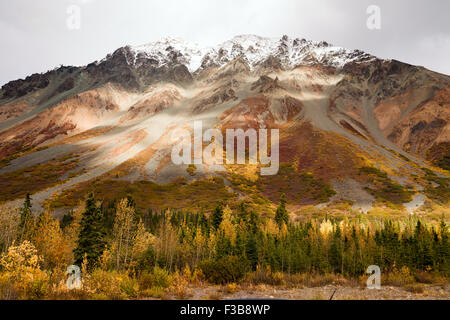 Il sole pigoli attraverso un poco nuvoloso cielo alla luce l'Alaska Range Foto Stock