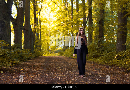 Il giovane bella strega nella foresta di autunno Foto Stock