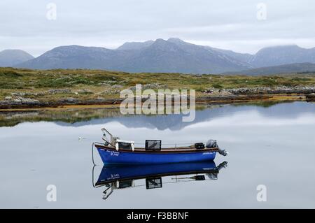 Blue barca da pesca riflette in mattina presto luce nel piccolo porto a Inishnee Connemara County Galway Irlanda Foto Stock