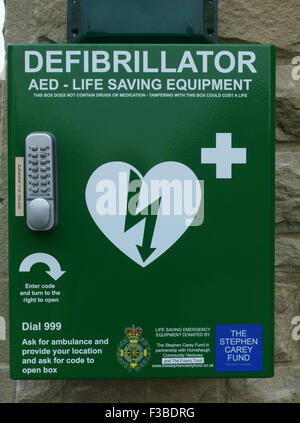 Defibrillatore attrezzature di salvataggio su village hall di Northumberland, Inghilterra Foto Stock