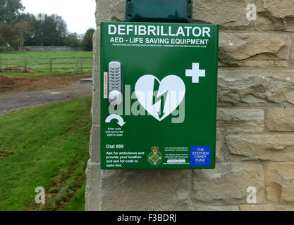 Defibrillatore attrezzature di salvataggio su village hall di Northumberland, Inghilterra Foto Stock