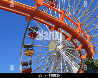 Le montagne russe e la ruota panoramica Ferris in un parco di divertimenti. Foto Stock