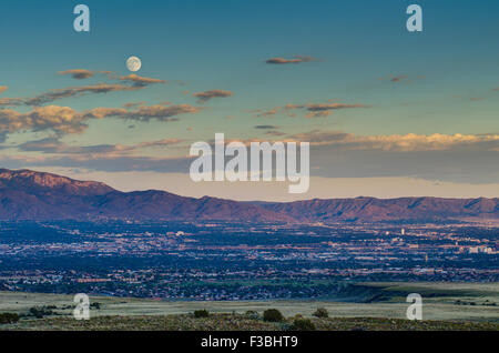 Luna piena sorgere oltre Albuquerque e Sandia Mountains, Nuovo Messico, Stati Uniti d'America. Foto Stock