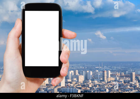 Concetto di viaggio - mano trattiene smartphone con tagliare fuori schermo e Paris panorama sullo sfondo Foto Stock