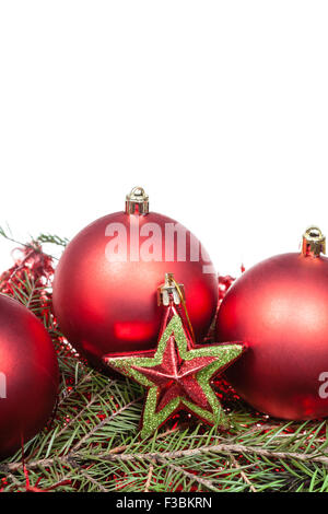 Stella Rossa e rosso baubles di Natale sul verde ramo di abete isolato su sfondo bianco Foto Stock