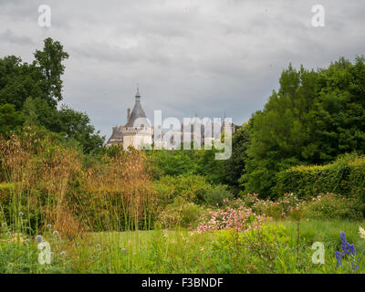 I tetti di punta del Chateau Chaumont-sur-Loire visto oltre il giardino di alberi Foto Stock