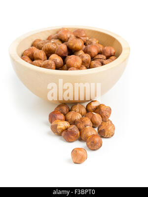 Pila di incrinato e nocciole sgusciate kernels nella ciotola di legno su sfondo bianco Foto Stock