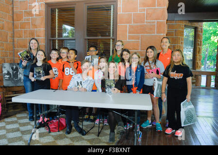 Emporia, Kansas, Stati Uniti d'America. Il 2 ottobre, 2015. William Allen White libro per bambini vincitori di premi. Gli autori (L-R) Madeline Herlong (a.k.a. M.H. Herlong) di New Orleans ha vinto con il suo libro "Buddy", Becky Wojahn (a.k.a. W.H. Beck) del Wisconsin ha vinto un premio per il suo libro "alcolm a mezzanotte' durante una sessione di autografi con la scuola i bambini da lontano come Weskan sul famoso portico di rocce rosse William Allen White's home. Credito: Credito: mark reinstein/Alamy Live News Foto Stock