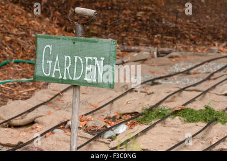 Segno del giardino e sacchi di tela che copre un orto di pacciame, proteggere da erbacce e preparazione per l'inverno dell', mostrando di gocciolamento tubi di irrigazione Foto Stock