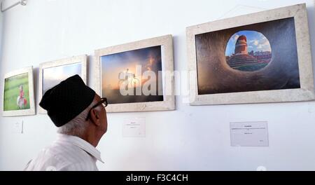 Kathmandu, Nepal. 4 Ott 2015. Un uomo guarda le foto sulla "Rebuilding Nepal' mostra fotografica a Kathmandu, Nepal, Ottobre 4, 2015. La mostra fotografica è organizzato per raccogliere fondi per il restauro di quake-hit templi da la Valle di Kathmandu Preservation Trust. © Sunil Sharma/Xinhua/Alamy Live News Foto Stock