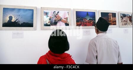 Kathmandu, Nepal. 4 Ott 2015. La gente guarda le foto sulla "Rebuilding Nepal' mostra fotografica a Kathmandu, Nepal, Ottobre 4, 2015. La mostra fotografica è organizzato per raccogliere fondi per il restauro di quake-hit templi da la Valle di Kathmandu Preservation Trust. © Sunil Sharma/Xinhua/Alamy Live News Foto Stock