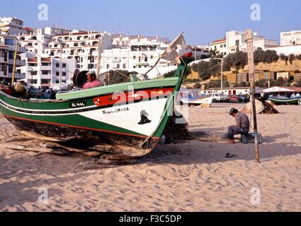 I pescatori con le loro tradizionali in legno barche da pesca ormeggiate sulla spiaggia, Albufeira, Algarve, Portogallo, Europa occidentale. Foto Stock