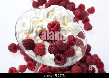 Panna montata in vetro frutta Lampone berry isolato studio contenitore prodotto dolce mangiare mangiabile ingredienti dolci close up macro Foto Stock