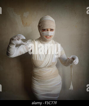 Donna avvolto in fasce come mummia egiziana costume di halloween fletching denti Foto Stock