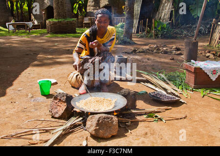 Donna Dorse arrosti i chicchi di caffè. Fotografato nella valle dell'Omo, Etiopia Foto Stock