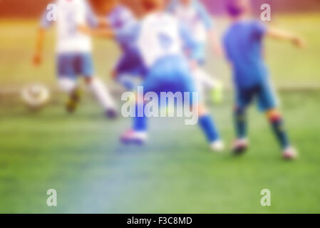 Ragazzi che giocano a calcio, defocussed blur sport immagine di sfondo Foto Stock