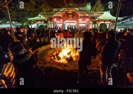 Anno nuovo, Giappone. Sacrario scintoista, Nishinomiya. La folla si riuniscono intorno al falò dove il precedente anno di buona fortuna charms, Omamori, sono saltati in. Notte. Foto Stock