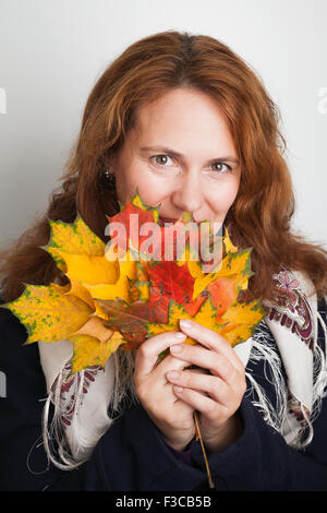 Ritratto di giovane e bella donna caucasica nel tradizionale russo collo sciarpa a colori d'autunno foglie di acero Foto Stock