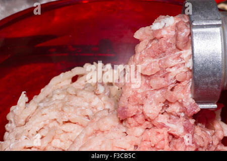 Preparazione di forcemeat fresca attraverso il tritacarne da fette di carne Foto Stock