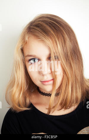 Bella bionda caucasica ragazza adolescente in nero. Ritratto in studio su sfondo bianco con ombra morbida Foto Stock