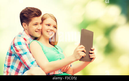 Coppia con tablet pc tenendo selfie su verde Foto Stock