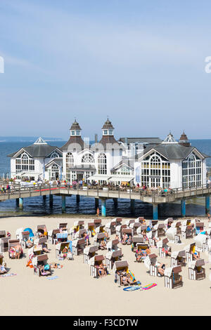 Vista del molo e molti Strandkorb tradizionali sedie a sdraio sulla spiaggia a Sellin resort sull isola di Rügen ,Germania Foto Stock