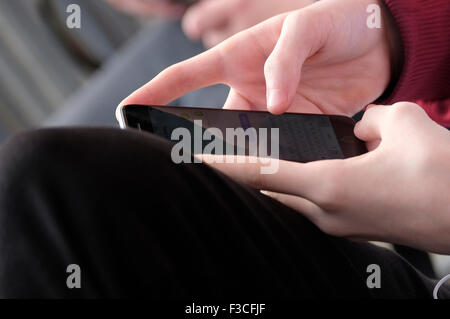 Giovane maschio adolescente utilizzando il telefono cellulare Foto Stock