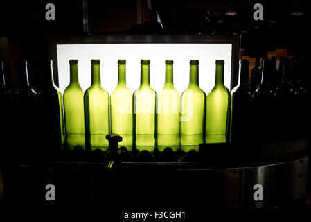 Le bottiglie di vino sulle moderne macchine imbottigliamento Foto Stock