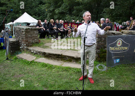 Il Hardraw Scaur Brass Band Festival. Tintwistle band con la loro band leader. Organizzato dalla Yorkshire e Humberside Brass Band Association, la concorrenza è la Gran Bretagna è il secondo più antico concorso esterno e si svolge ogni anno in Hardraw cicatrice Wensleydale, North Yorkshire, Inghilterra, Regno Unito. L'area, un anfiteatro naturale, attira musicisti provenienti da tutto il nord dell'Inghilterra e è una manifestazione popolare tra attori e spettatori allo stesso modo. Foto Stock