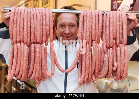 Dispensa - di un documento di riferimento mostra macellaio Dirk Ludwig con salsicce bratwurst realizzato da costosi del manzo di Kobe, nella sua macelleria in Schluechtern, Germania, 11 settembre 2015. La carne di giapponese bovini Kobe è il più costoso di carni bovine nel mondo, con al chilo dei prezzi fino a 400 euro. Foto: DOMINIK H. ROSSBACH/DPA Foto Stock