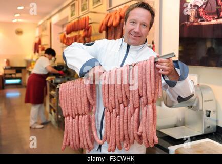 Dispensa - di un documento di riferimento mostra macellaio Dirk Ludwig con salsicce bratwurst realizzato da costosi del manzo di Kobe, nella sua macelleria in Schluechtern, Germania, 11 settembre 2015. La carne di giapponese bovini Kobe è il più costoso di carni bovine nel mondo, con al chilo dei prezzi fino a 400 euro. Foto: DOMINIK H. ROSSBACH/DPA Foto Stock