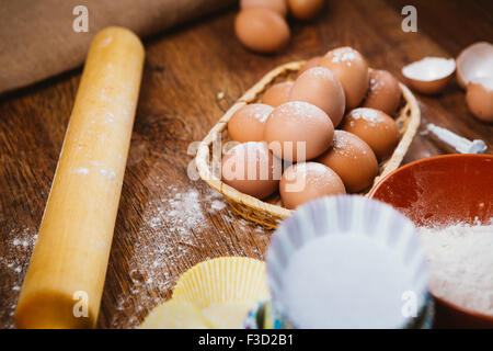 Colorful cupcake wrapper con teglia su sfondo di cucina Foto Stock