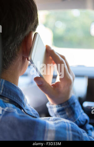 Uomo in auto parlando al telefono cellulare durante la guida Foto Stock