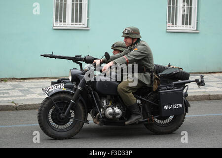 Reenactors uniformata come nazista tedesco soldati guidare una moto durante la rievocazione storica del 1945 insurrezione di Praga a Praga, nella Repubblica Ceca il 9 maggio 2015. Foto Stock