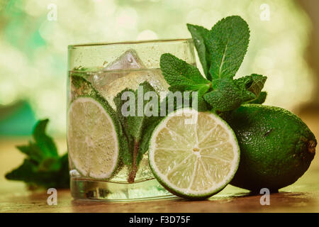 Cocktail Mojito con lime fresco sulla tavola di legno Foto Stock