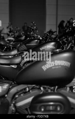 Una fila di simili Harley Davidson Moto line up nel buio di una parcheggio auto a notte. Foto Stock