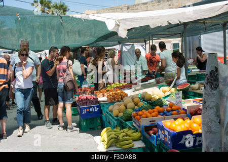 I turisti e la gente del posto lo shopping al Domenica mattina mercato organizzato di Marsaxlokk Malta ogni fine settimana. Foto Stock