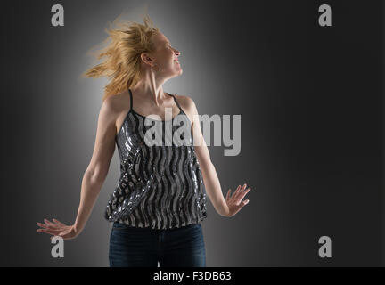 Happy woman dancing in studio Foto Stock