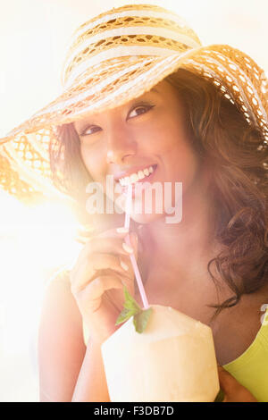 Giovane donna con drink in presenza di luce solare Foto Stock