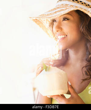 Giovane donna con drink in presenza di luce solare Foto Stock