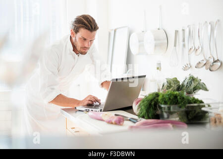 Chef utilizzando laptop in cucina Foto Stock