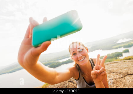 Giovane donna prendendo selfie sullo smartphone Foto Stock