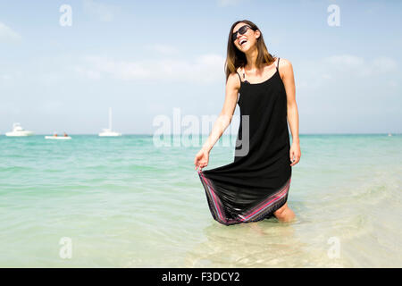 Donna che cammina sulla spiaggia Foto Stock