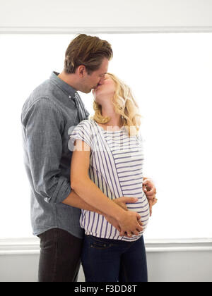 Il marito baciare moglie incinta Foto Stock