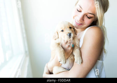 Donna che mantiene il Golden Retriever cucciolo Foto Stock